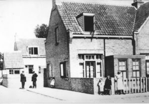 Op de hoek Franklinstraat en de De Lessepsstraat volgt men het werk van de fotograaf. Dat wil zeggen, de personen op de voorgrond. De heren laten zich er niet door afleiden (of hebben zij een discussie over het camerastandpunt?).