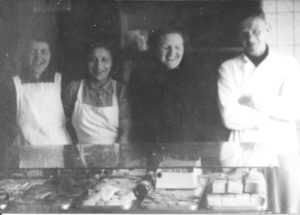 In de winkel van Bakkerij ‘De Tijdgeest’ in de Swammerdam-straat 12 staat het personeel achter de toonbank u vriendelijk toe te lachen. V.l.n.r. Jo Plantinga, E.C. Stekelenburg, juffrouw Wegrif en Kobus de bakker is er ook even bij komen staan.